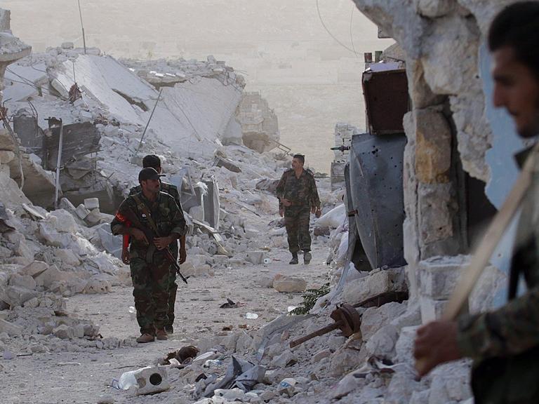 Sie sehen syrische Soldaten in einem Flüchtlingslager in Aleppo.