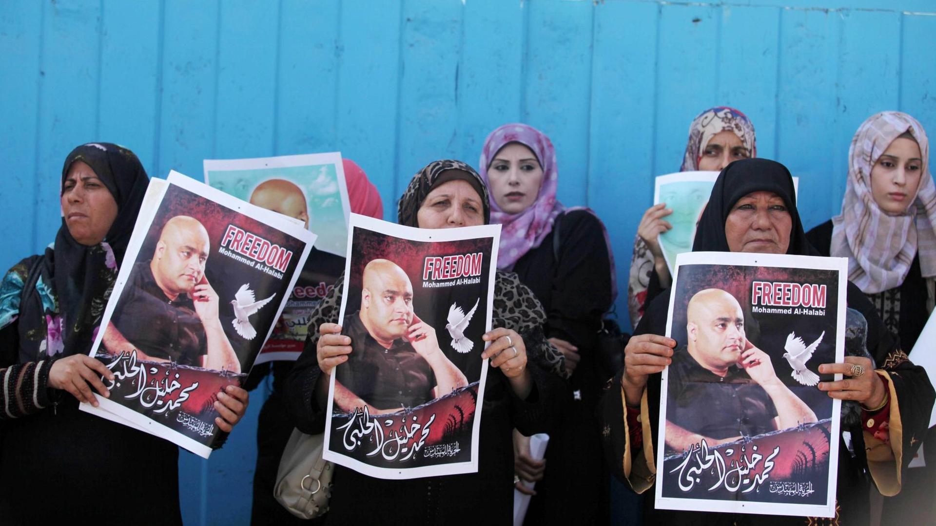 Frauen in Gaza Stadt halten Plakate, auf denen sie die Freilassung von Mohammed El Halabi fordern.