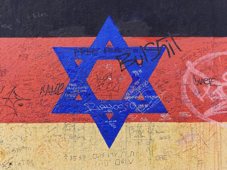 Wandgemälde einer deutsche Flagge mit Davidstern an der East Side Gallery in Berlin. Copyright: imageBROKER/EgonxBömsch