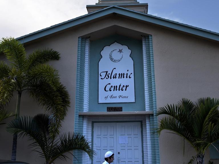 Ein Mann vor einem kirchenähnlichen Gebäude mit der Aufschrift "Islamic Center"