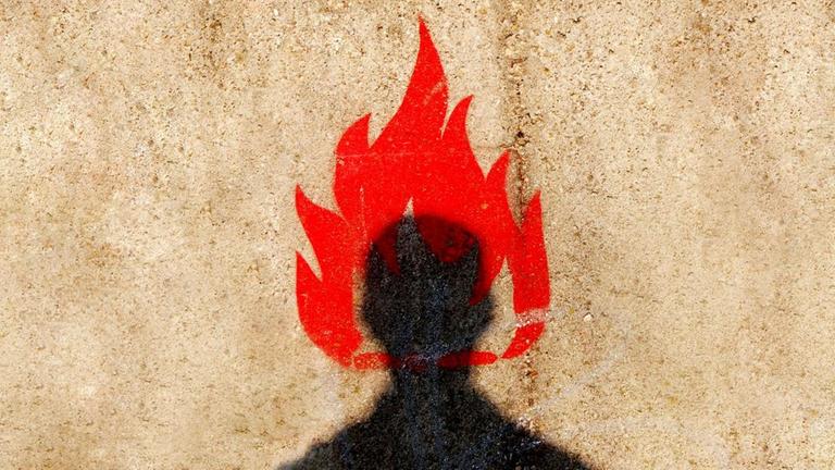 Auf einer verputzten Häuserwand ist ein stilisierter schwarzer Männerkopf mit einer roten Flamme zu sehen.