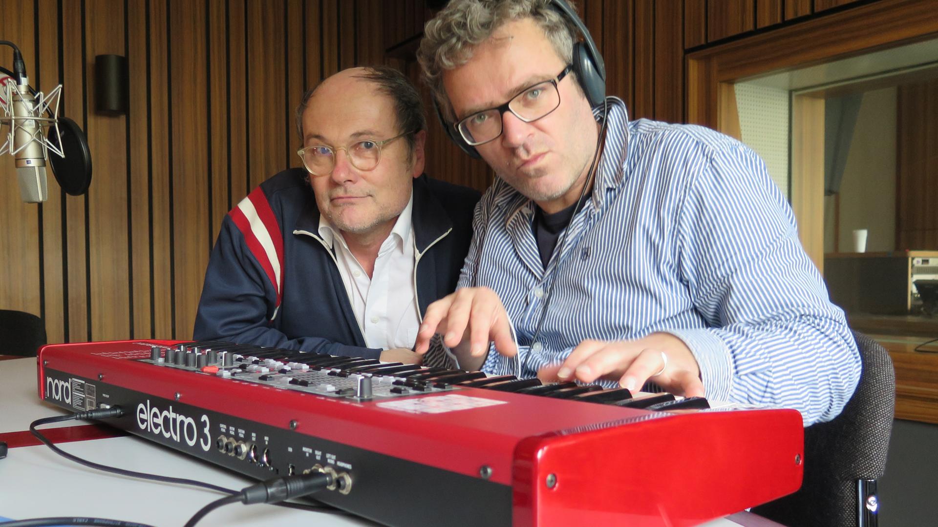 Musik und Kabarett - Pigor & Eichhorn zu Gast im Funkhaus von Deutschlandradio Kultur. Beide lehnen hinter einem roten Keyboard und schauen in die Kamera.