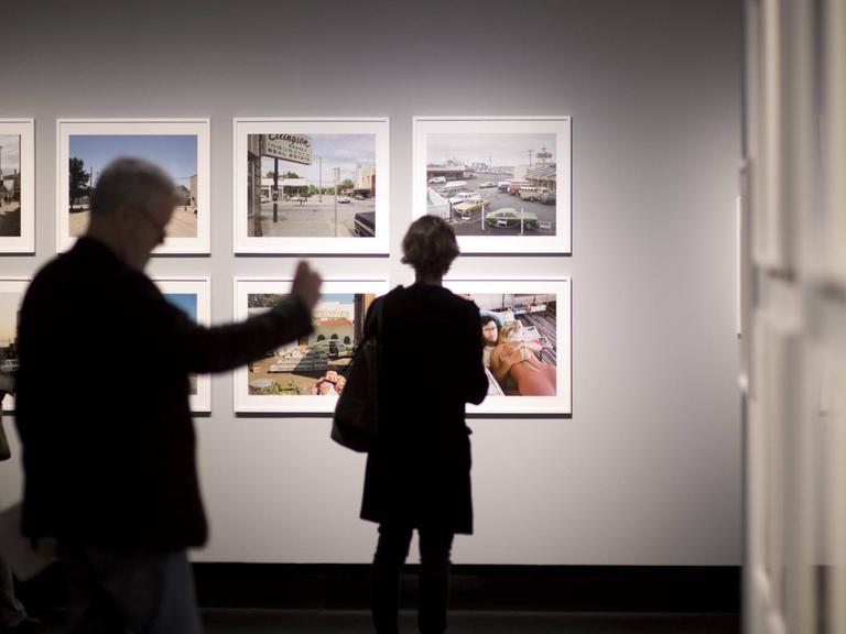 Ein Ausstellungsbesucher fotografiert mit seinem Smartphone ein gezeigtes Kunstwerk.