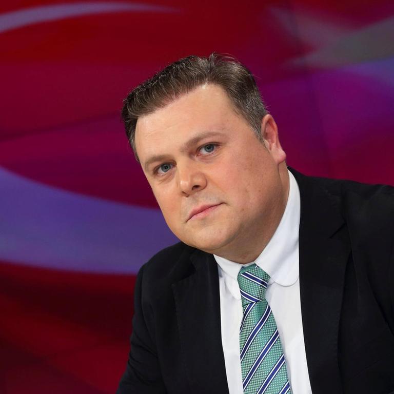 Bülent Bilgi (Generalsekretär Union Europäisch-Türkischer Demokraten in der ZDF-Talkshow Maybrit Illner am 14.04.2016 in Berlin. Im Hintergrund ist eine Türkei-Flagge zu sehen.