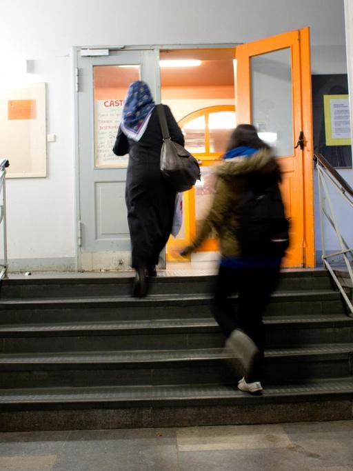 Zwei Mitarbeiter einer Sicherheitsfirma bewachen an der Berliner Albert-Schweitzer-Schule den Eingang