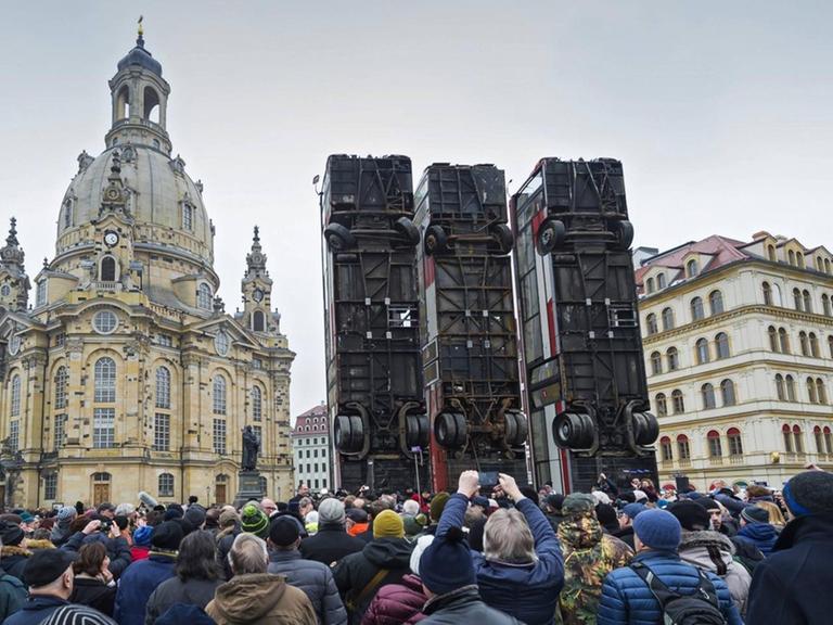 Auf dem zentralen Neumarkt vor der Frauenkirche hat der Deutsch-Syrier Manaf Halbouni drei ausrangierte Buswracks hochkant aufstellen lassen. Sie sollen an den Krieg und das Leid der Zivilbevölkerung in Syrien erinnern.