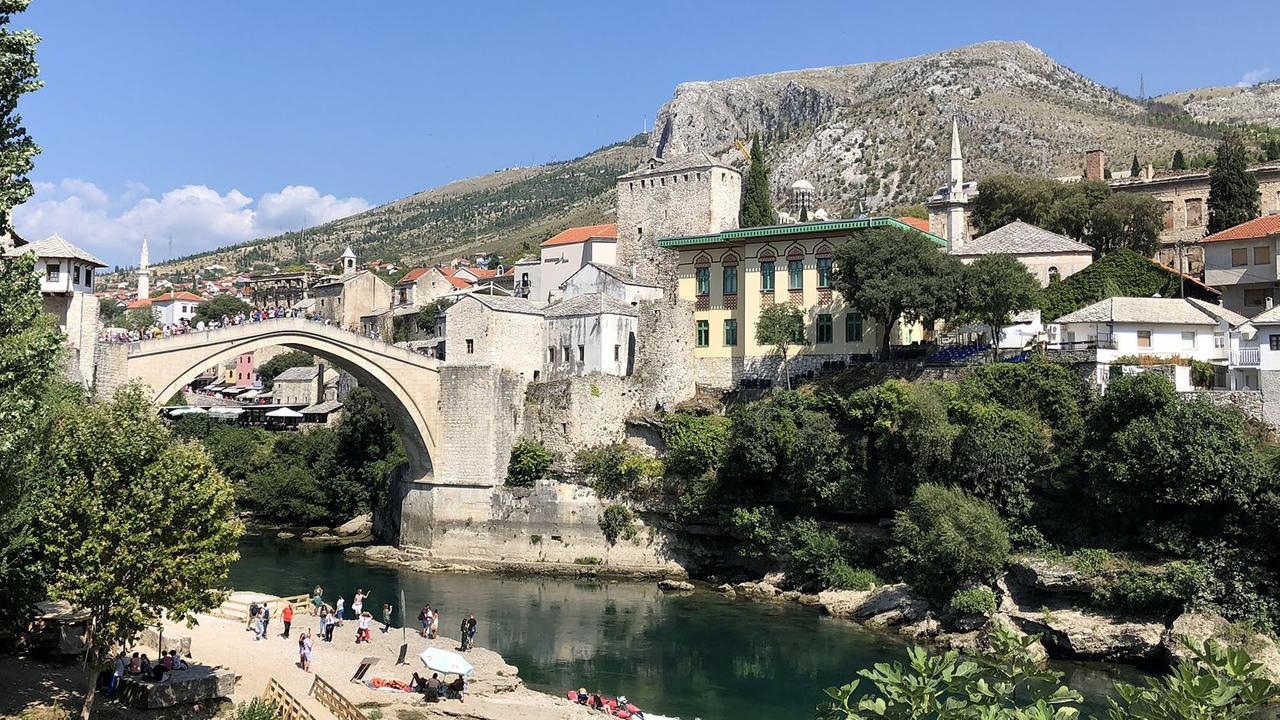 Touristen strömen über das Wahrzeichen von Mostar: die wiederaufgebaute Brücke über die Neretva.