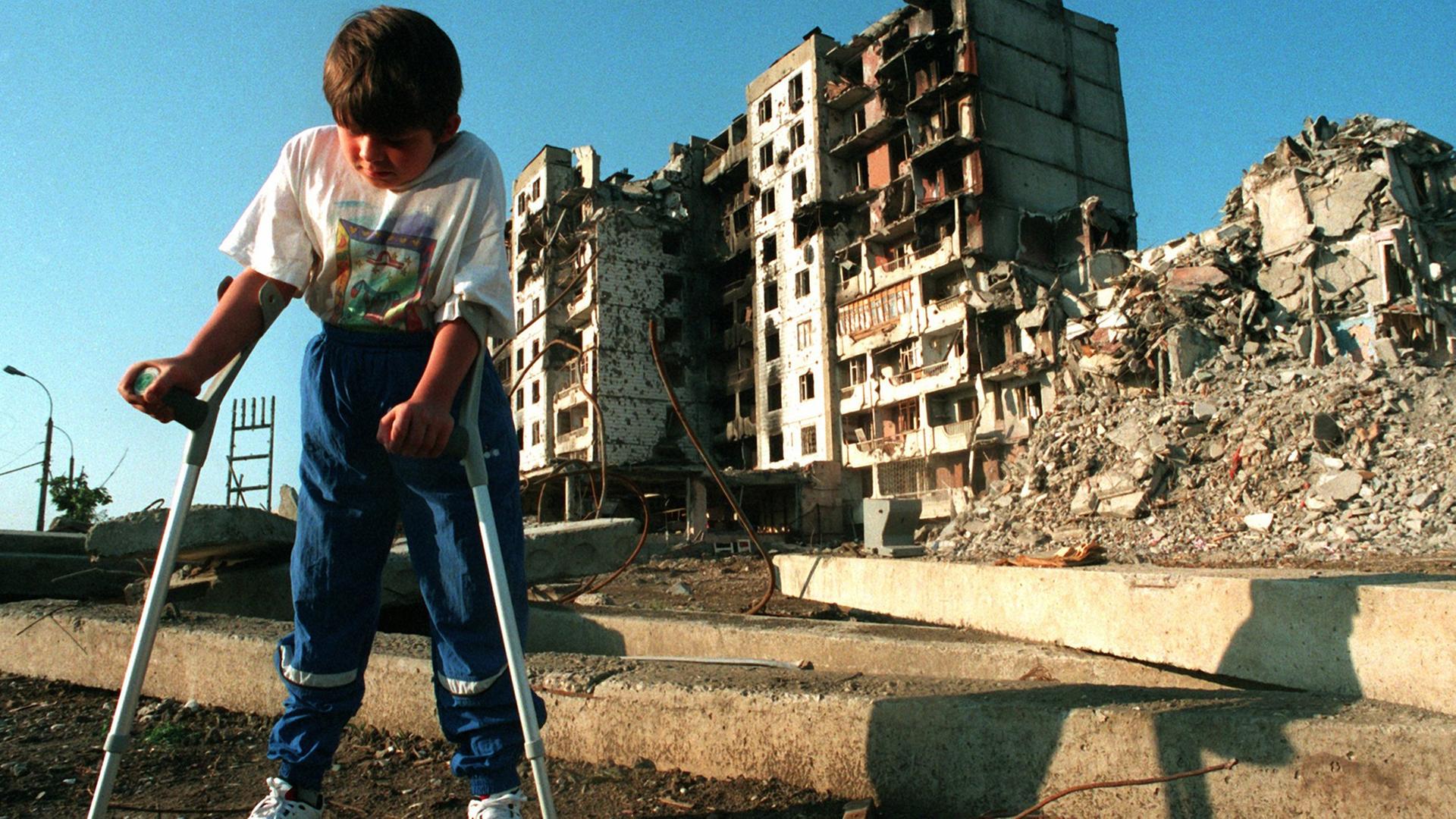 31.7.1995: Der achtjährige tschetschenische Junge Mischa Jepiphantschew geht auf Krücken durch die Straßen von Grosny.