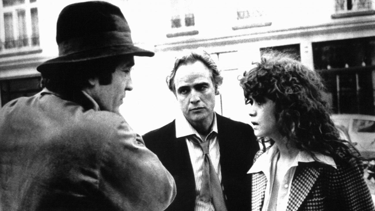 Der italienische Regisseur Bernardo Bertolucci (l) im Gespräch mit seinen Hauptdarstellern Marlon Brando (M) und Maria Schneider bei den Dreharbeiten zu dem Film "Der letzte Tango in Paris" 1972.