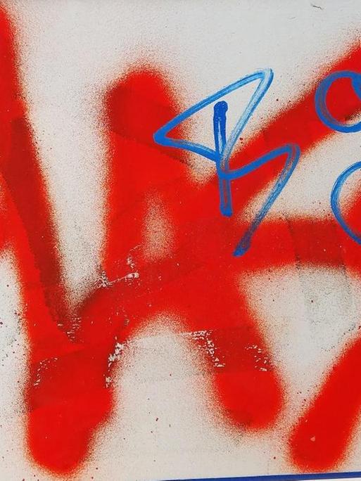 Das Wort "Hass" steht gesprüht in roter Farbe auf einem Stromkasten.