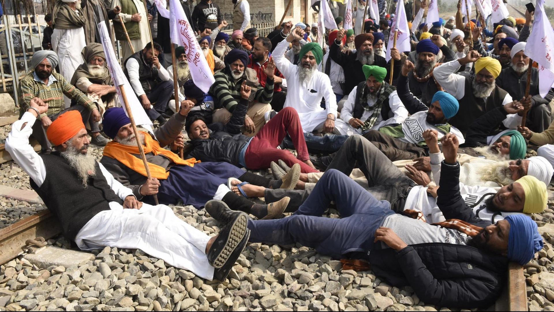 Indien, Neu-Delhi: Bauern blockieren einen Zuggleis im Rahmen ihrer Proteste gegen die umstrittene Reform des Agrarsektors.