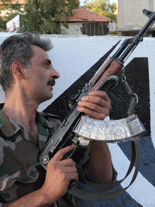Ein syrischer Soldat mit Maschinengewehr an einem Kontrollpunkt in Damaskus.