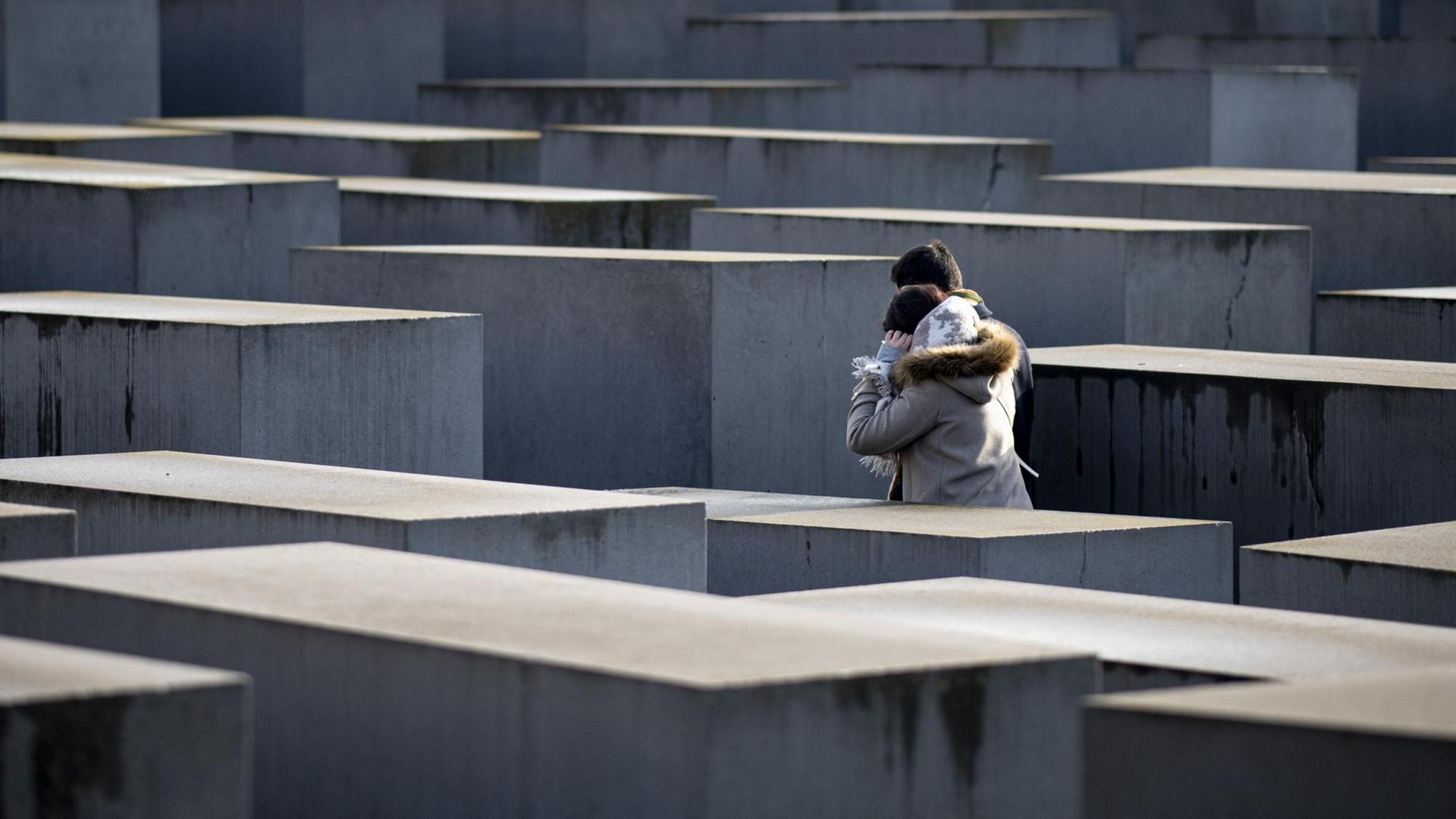 Zwei Personen gehen vor dem Internationalen Tag des Gedenkens an die Opfer des Holocaust durch das Denkmal für die ermordeten Juden Europas. Der Holocaust-Gedenktag wird am 27.01.2021 begangen.