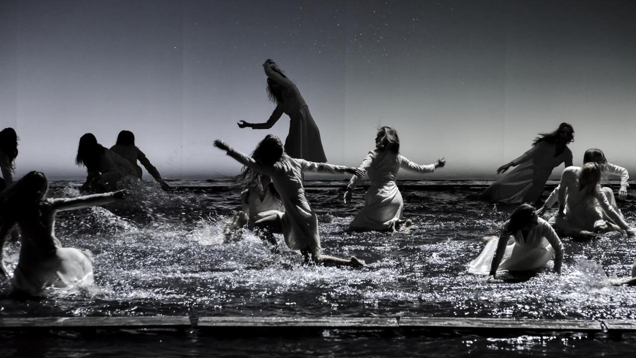 Viele Frauen tanzen nymphenartig im Wasser.