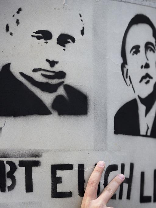"Habt euch lieb" steht am Potsdamer Platz in Berlin auf einem Plakat mit den Portraits von Wladimir Putin und Barack Obama.