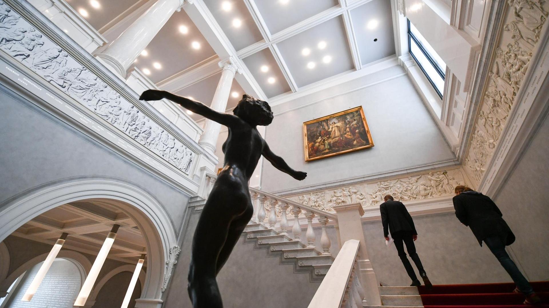 Mitarbeiter gehen einen Treppenaufgang in der geschlossenen Alten Nationalgalerie hinauf, bevor die ersten Besucher mit neuer Wegeleitung hinein dürfen.