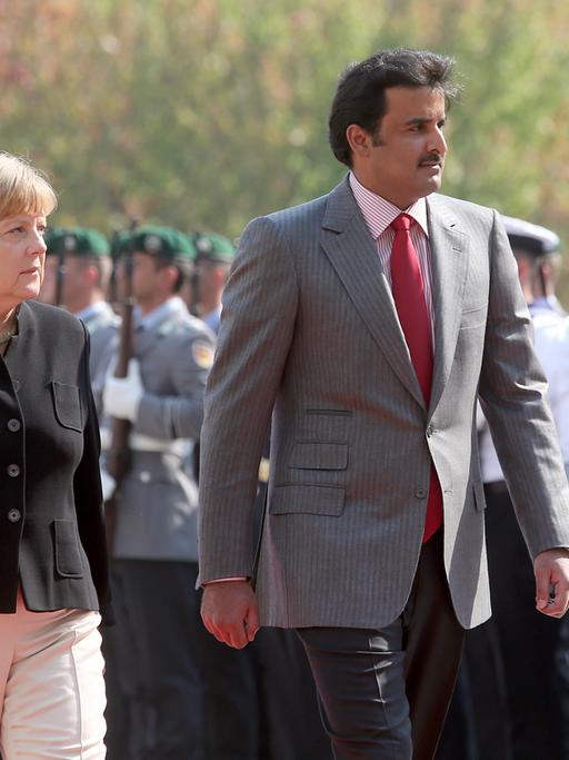 Bundeskanzlerin Merkel und der Emir von Katar, Scheich al-Thani, nehmen die Ehrenformation vor dem Bundeskanzleramt ab.
