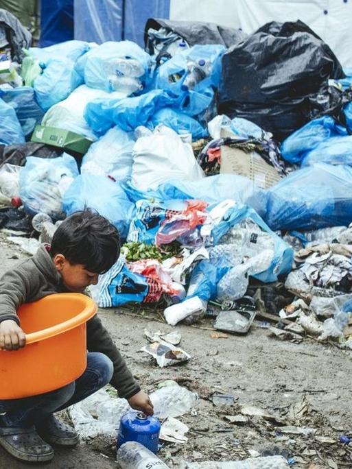 Das Foto zeigt ein Kind, das im Flüchtlingslager Moria auf Lesbos Müll nach Verwertbarem durchsucht - die Zustände in dem Lager sind kaum noch zu beschreiben.