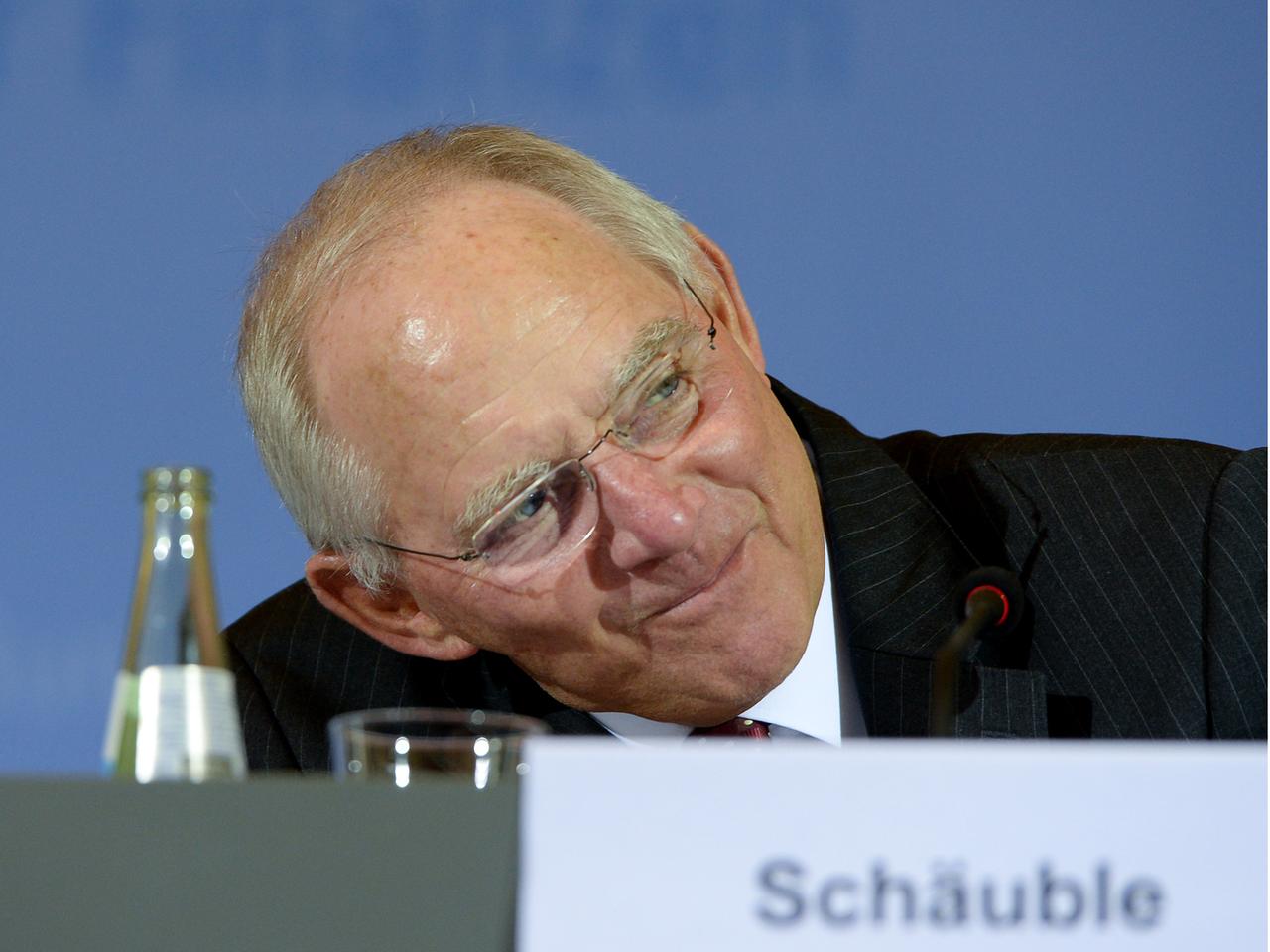 Bundesfinanzminister Wolfgang Schäuble wartet während einer Pressekonferenz in Berlin zu den Ergebnissen der Steuerschätzung auf Fragen der Journalisten. Er legt den Kopf zur Seite und lächelt.