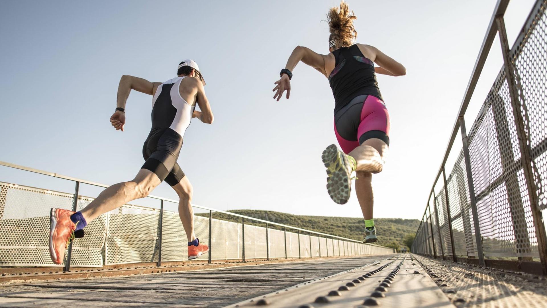 Two athletes running on a bridge model released Symbolfoto