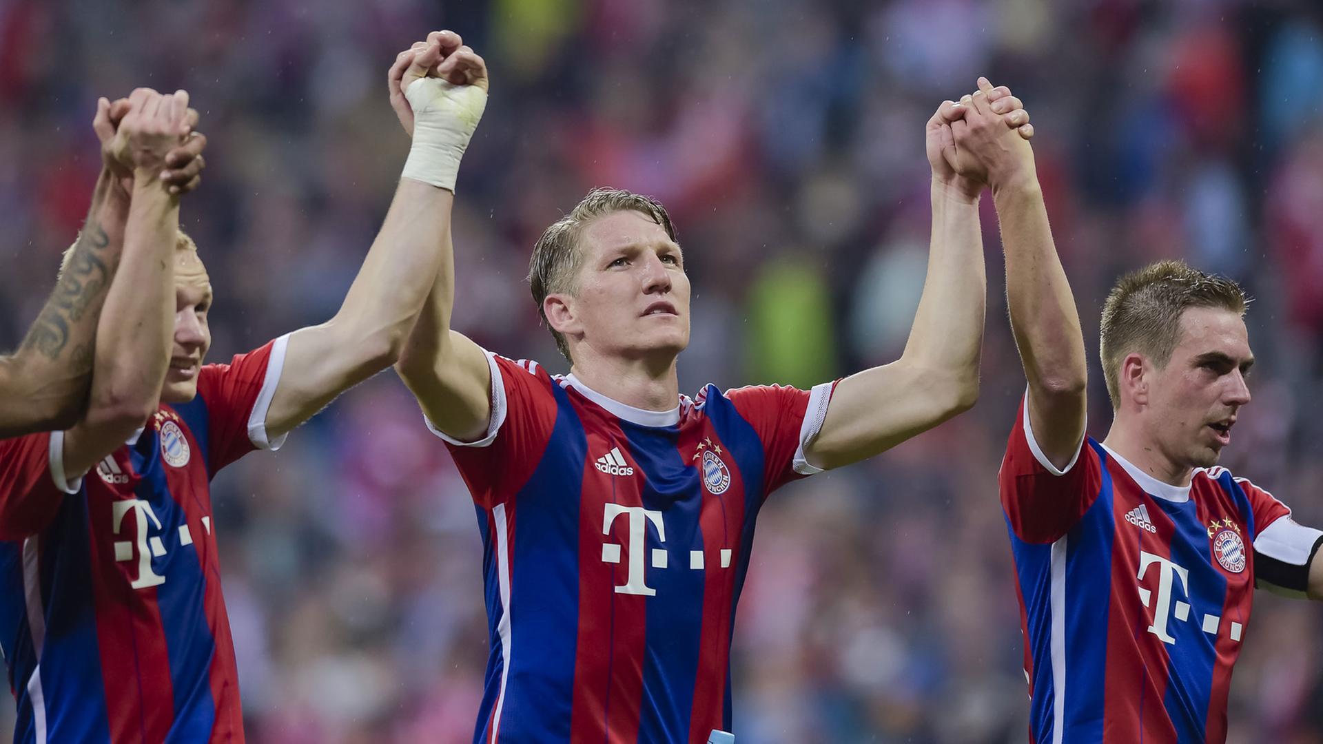 Die Bayern-Spieler Bastian Schweinsteiger (mitte) und Philipp Lahm (rechts) jubeln nach dem 1:0-Sieg gegen Herta BSC und strecken die Hände hoch.