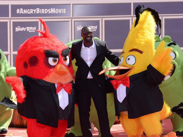 Der Schauspieler Omar Sy mit Filmfiguren bei der Premiere von "Angry Birds Movie" beim 69. Filmfestspiel in Cannes am 10.05.2016.