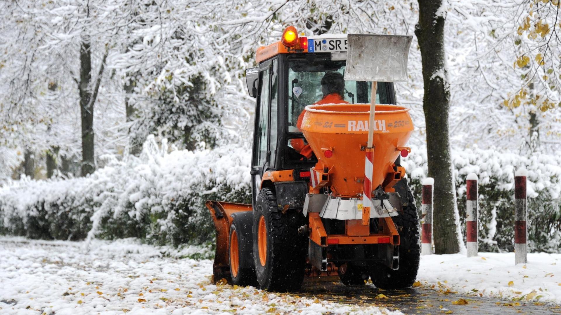 Ein Kehrfahrzeug mit Schneepflug räumt in München den Schnee auf einem Gehweg.