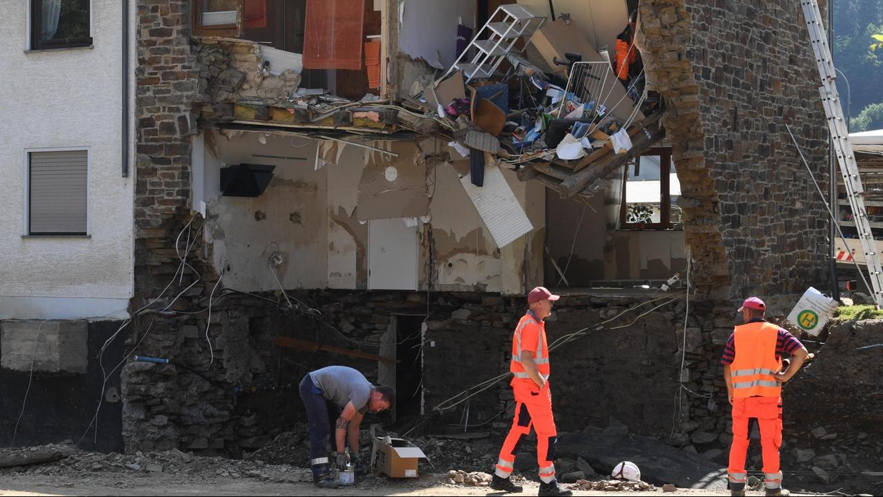 Helfer und Anwohner räumen vor einem zerstörten Haus in Kirchsahr auf. Hochwasserkatastrophe in NRW am 20.07.2021.