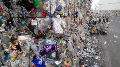 Es stehen riesige Gebinde von Plastimüll auf einem Hof in einer Müllsortieranlage