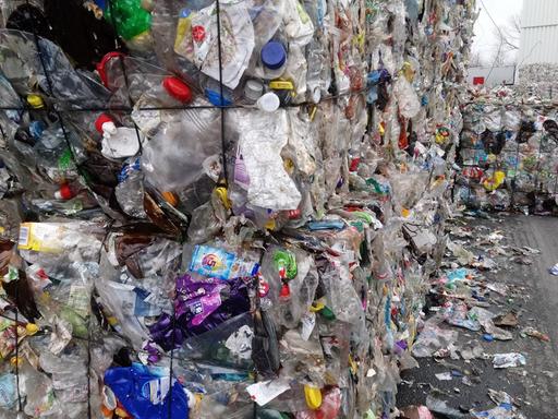 Es stehen riesige Gebinde von Plastimüll auf einem Hof in einer Müllsortieranlage
