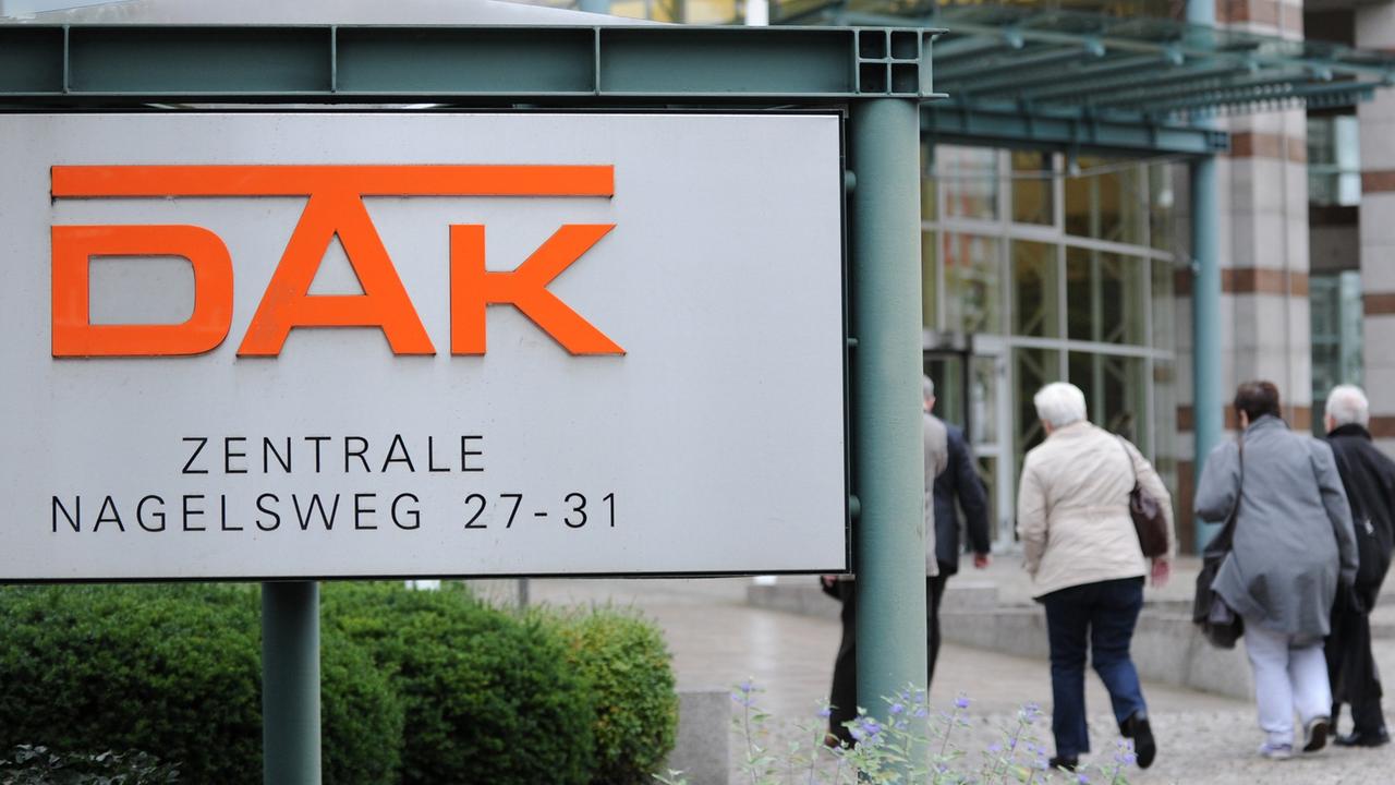 Passanten gehen in Hamburg auf den Eingang der Zentrale der DAK zu.