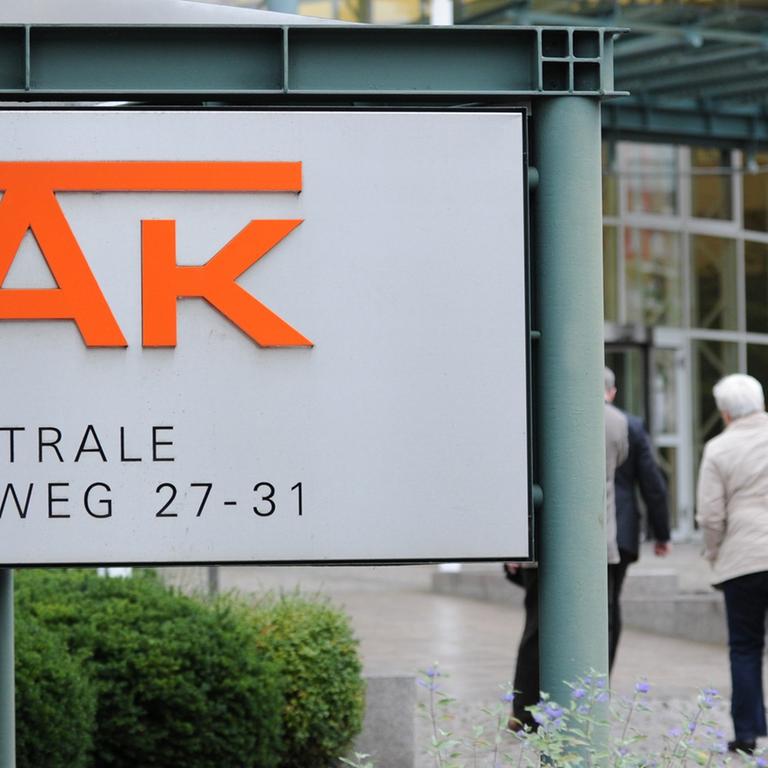 Passanten gehen in Hamburg auf den Eingang der Zentrale der DAK zu.