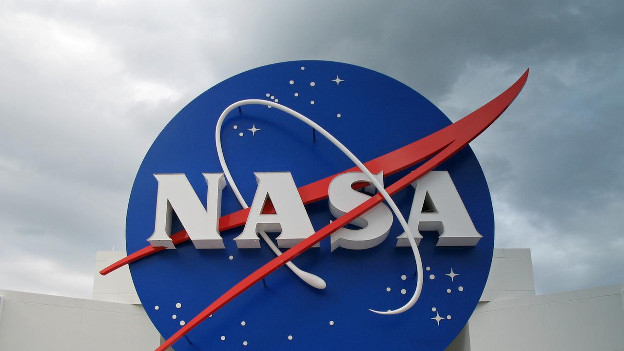 NASA-Logo auf dem Gelände in Cape Canaveral, weiße Schrift auf blauem Untergrund, mit rotem Strich über der Schrift.