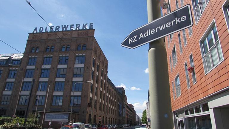 Ein Straßenschild mit der Aufschrift "KZ Adlerwerke" zeigt auf das Gebäude der Adlerwerke in Frankfurt.