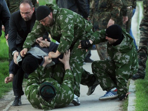Prorussische Mililzen überwältigen einen Mann in Belbek auf der Krim