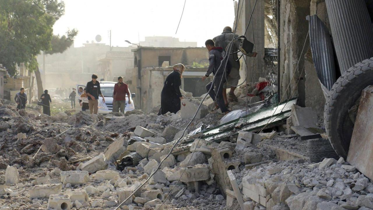 Dieses Bild zeigt am 13.11.2017 in Aleppo (Syrien) Bewohner, die die Trümmer eines Gebäudes durchsuchen. 