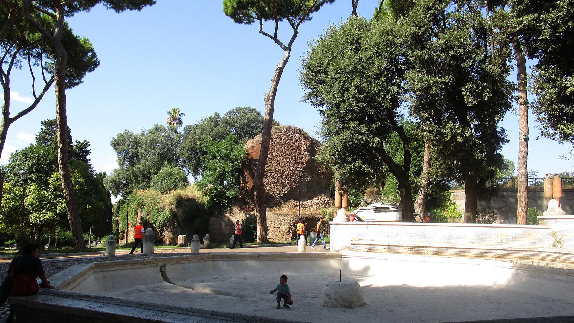 Kinder spielen im Oppio-Park in Rom in einem trockenen Brunnen am künftigen Martin-Luther-Platz.