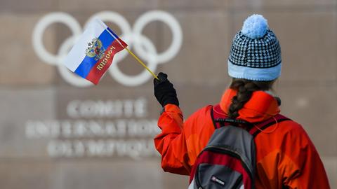 Eine Frau hält eine russische Fahne vor dem IOC-Gebäude in Lausanne.