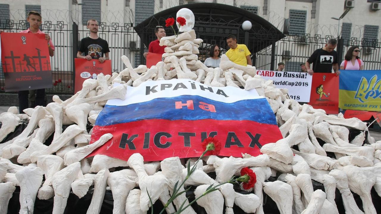 Kiew: Demonstration für Oleg Sentsov und andere politisch Gefangene in Russland - Aktivisten haben einen Schädel und Knochen aus Pappmaché haben Aktivisten vor der russischen Botschaft in Kiev aufgetürmt 