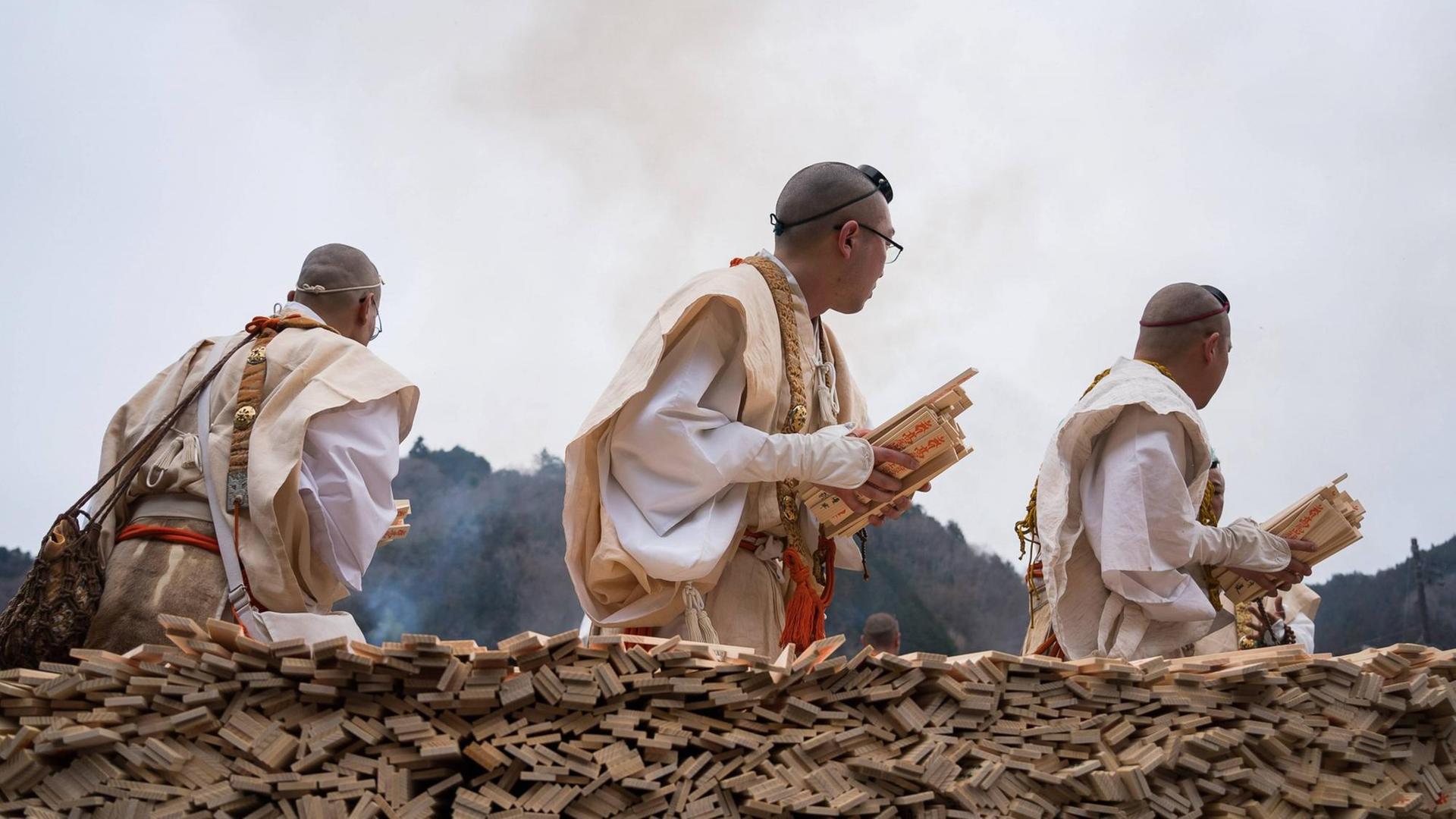 Yamabushi Mönche mit Holzstücken in den Händen, während einer Feuerzeremonie, die das Kommen des Frühlings im Yakuoin-Tempel auf dem Berg ankündigt, Mai 2019.