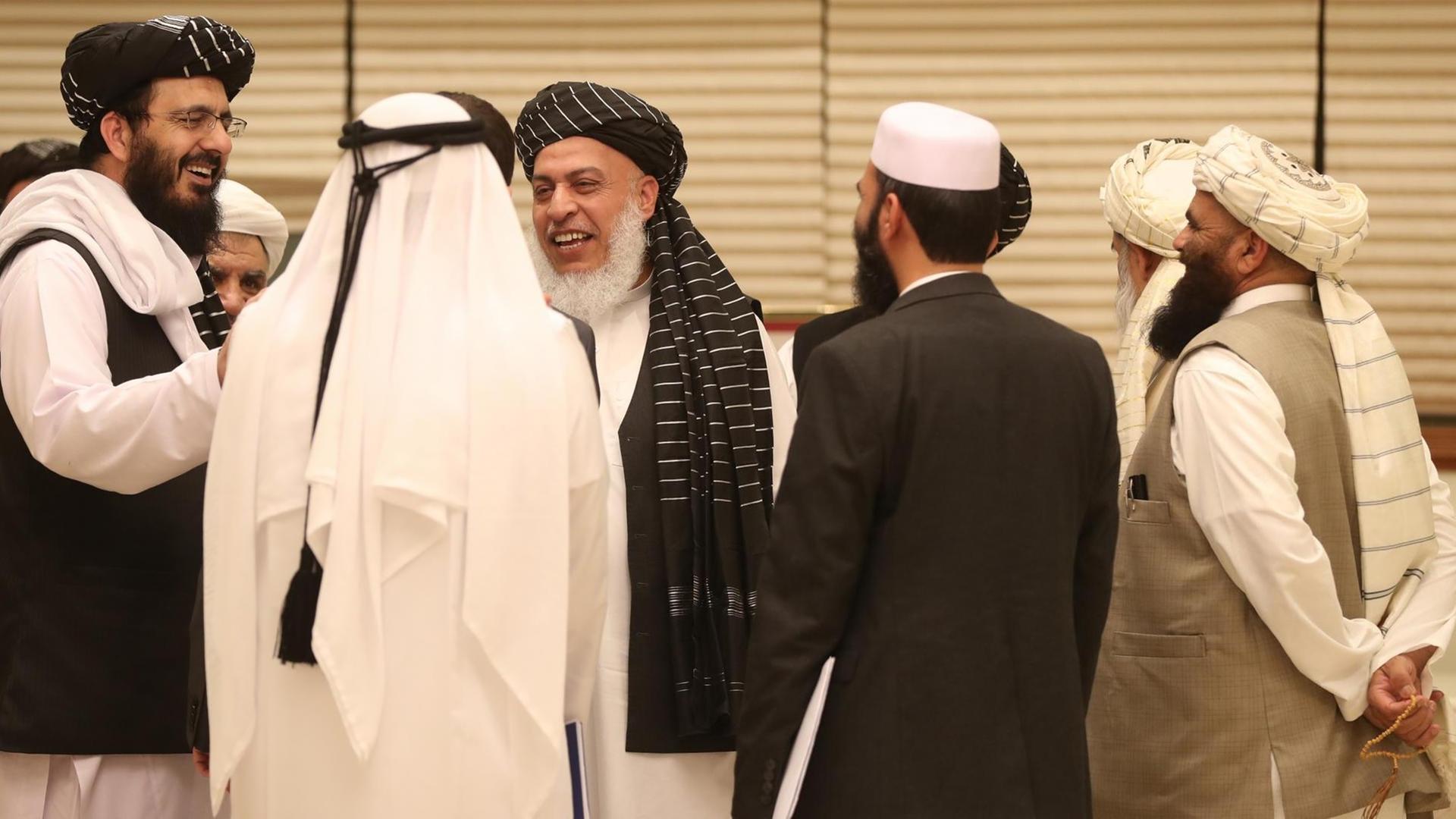 Members of Afghan delegations gather during the second day of the Intra Afghan Dialogue talks in the Qatari capital Doha on July 8, 2019. - Dozens of powerful Afghans met with a Taliban delegation on July 8, amid separate talks between the US and the insurgents seeking to end 18 years of war. The separate intra-Afghan talks are attended by around 60 delegates, including political figures, women and other Afghan stakeholders. (Photo by KARIM JAAFAR / AFP)
