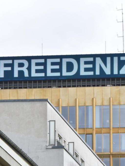 #FREEDENIZ steht in weißer Schrift auf blauem Untergrund am Dach der Konzernzentrale der Springer SE. Daneben das Konterfei von Deniz Yücel.