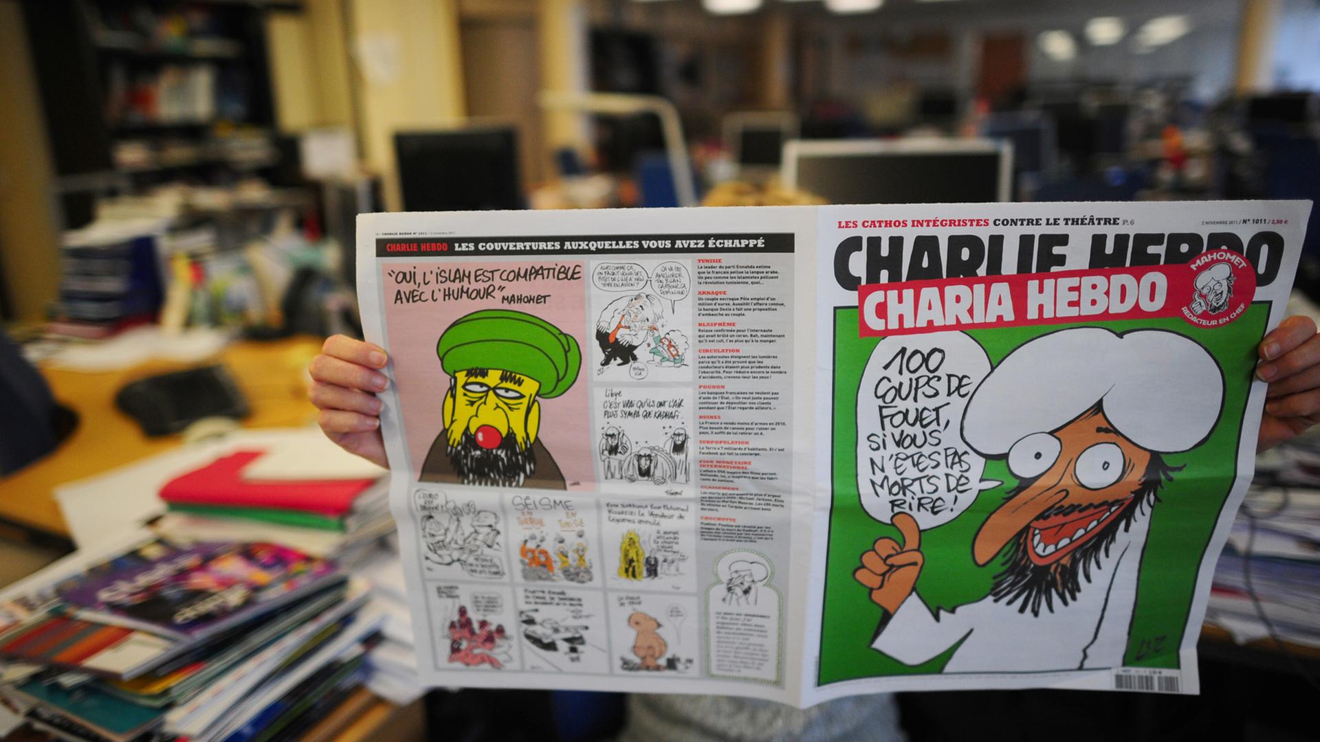 Ein Mann liest eine ältere Ausgabe von Charlie Hebdo mit einer Karikatur von Mohammed.