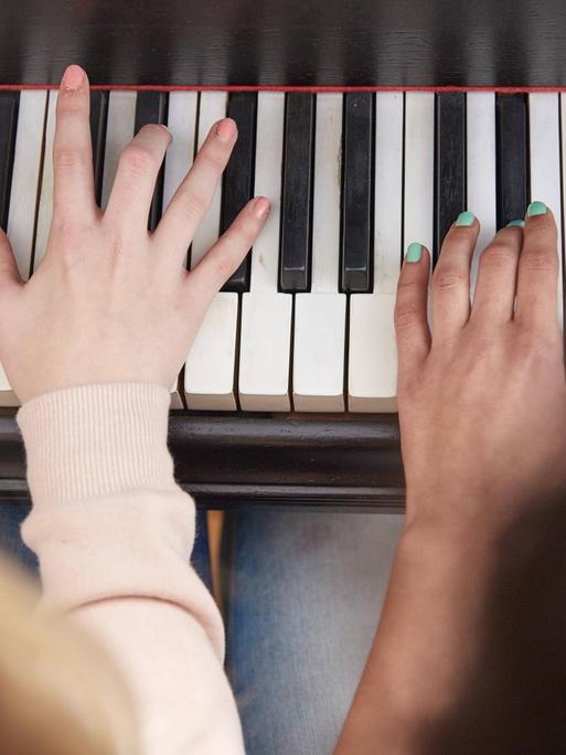 Nahaufnahme von zwei Mädchen, die Klavier spielen