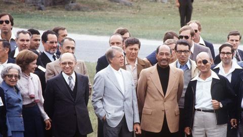 US-Präsident Jimmy Carter (Mitte) mit Anwar as-Sadat (rechts) und Menachem Begin (links) in Camp David. Links am Rand steht Rosalyn Carter.