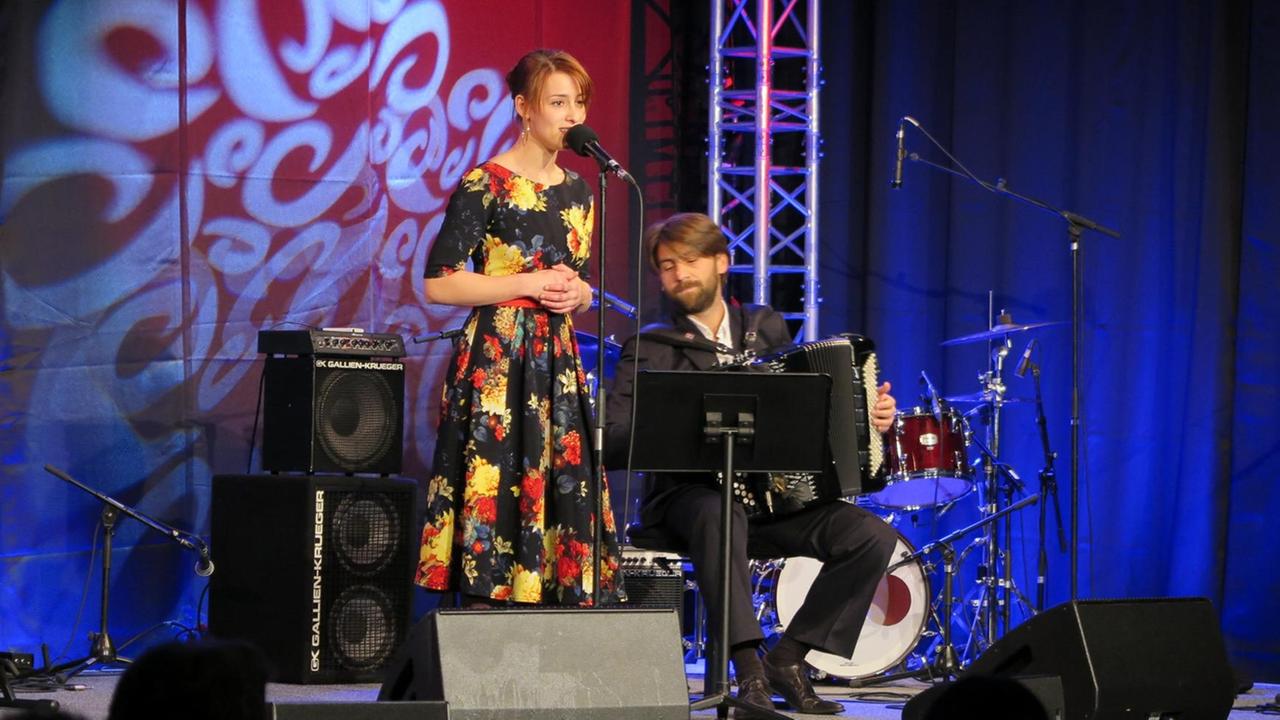 Christina Scherrer in geblümtem Kleid steht am Mikrofon nehmen ihr der Akkordeonist Andrej Prozorov