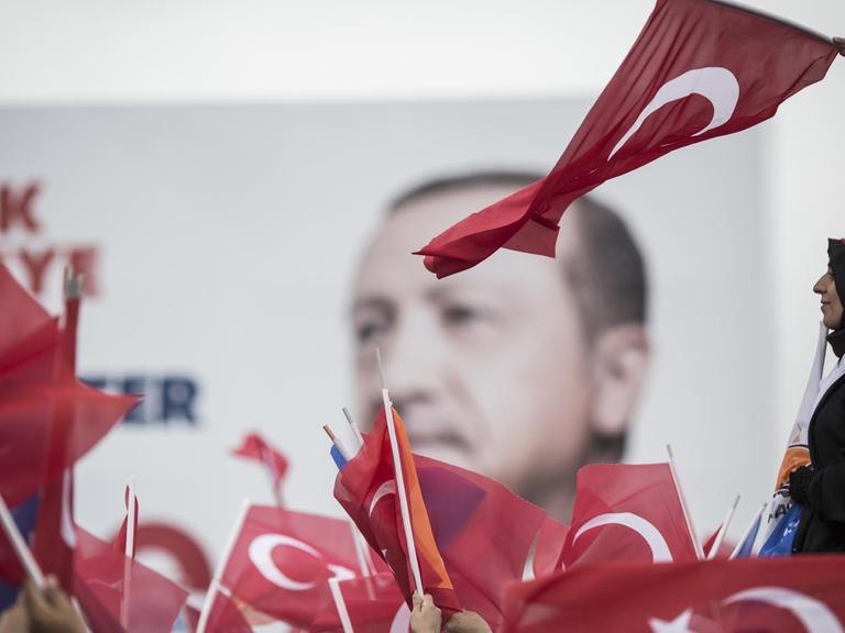 Anhänger des türkischen Präsidenten Recep Tayyip Erdogan verfolgen fahnenschwingend eine seiner Wahlkampfreden.