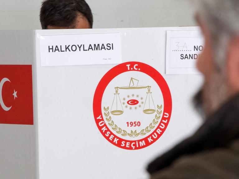 Ein Türke steht am 27.03.2017 in München (Bayern) in einem Wahllokal in der Wahlkabine.
