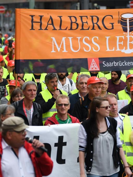 Beschäftigte des Autozulieferers Neue Halberg Guss (NHG) ziehen während einer Demonstration mit einem Transparent mit der Aufschrift "Halberg Guss muss leben" durch das Frankfurter Bahnhofsviertel.