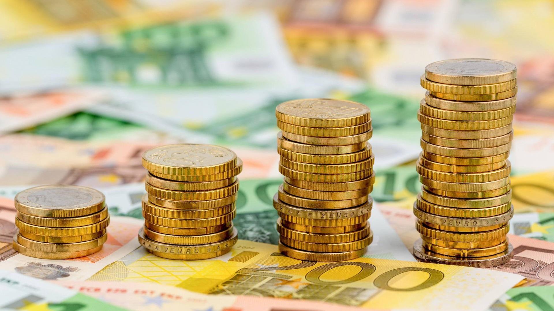 Ein Stapel Geld-Münzen auf Euro-Scheinen